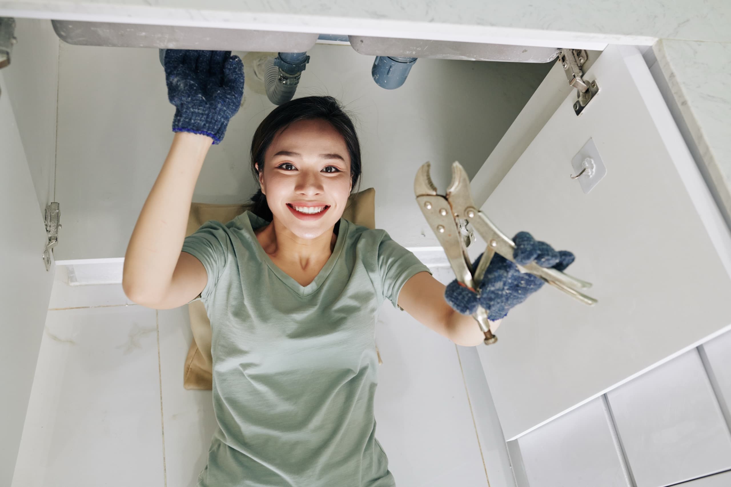 Woman fixing kitchen sink