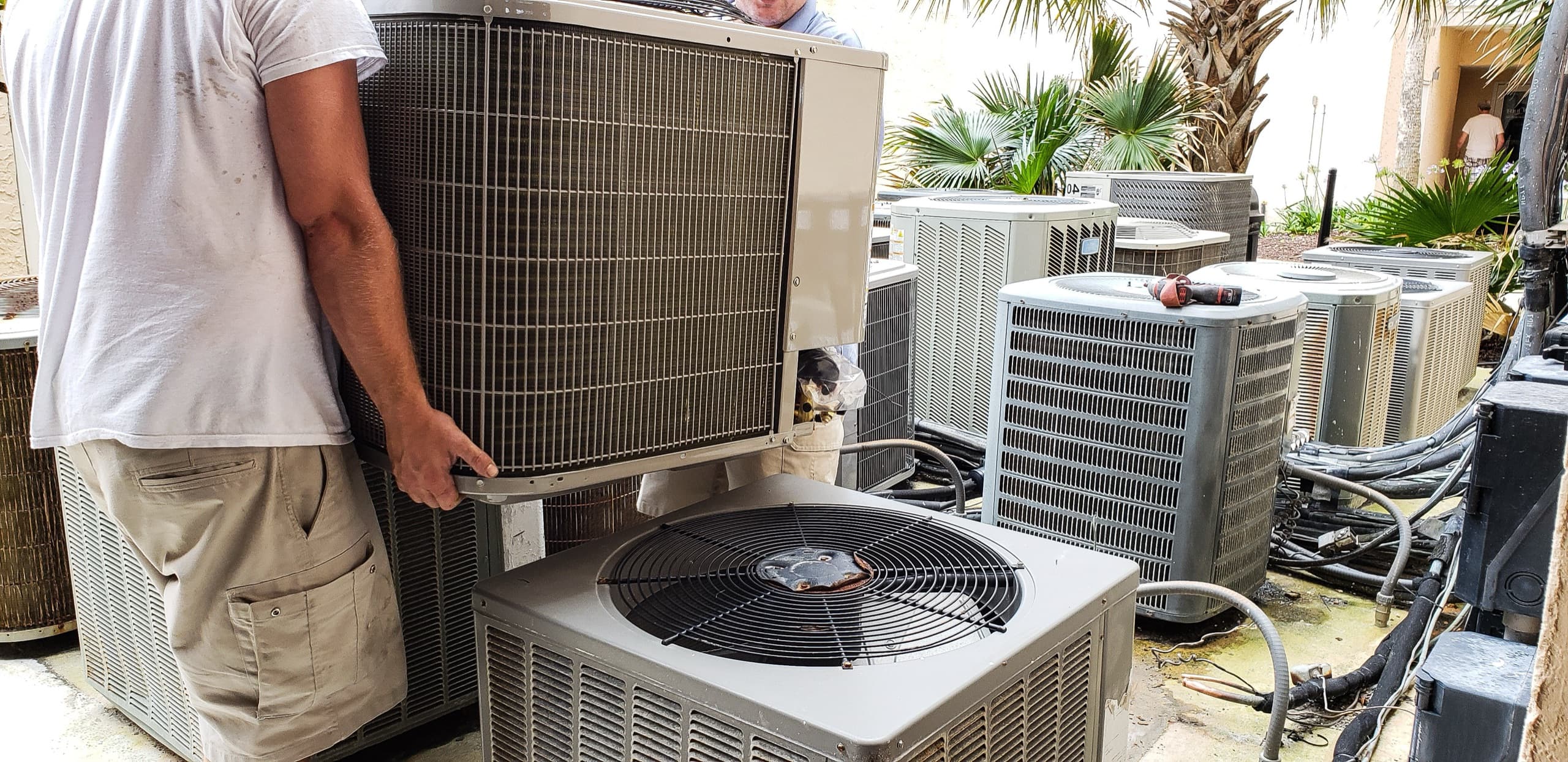 Workers installing heating and cooling unit